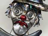 a metal statue of a clown with a hat and a knife