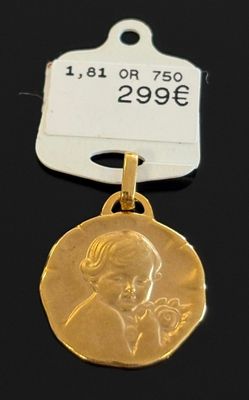 un gros plan d'une médaille d'or à laquelle est attachée une étiquette
