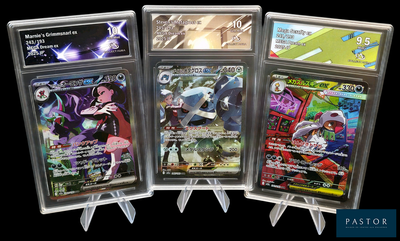 Quatre cartes Pokémon différentes sont exposées dans une vitrine.