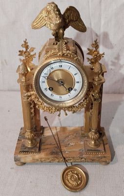 une horloge en or surmontée d'un aigle