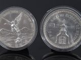 an image of a pair of silver coins sitting on top of a black surface