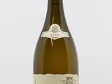 une bouteille de vin blanc posée sur une table blanche
