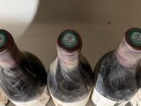 several bottles of wine are lined up in a row on a counter