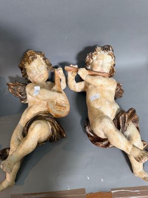deux figurines représentant Cupidon en train de jouer de la musique, posées sur une table