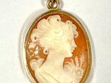 un pendentif plaqué or représente le profil d'une femme