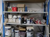 a room with a shelf full of paint and supplies