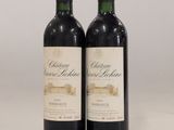 deux bouteilles de vin rouge posées sur une table blanche