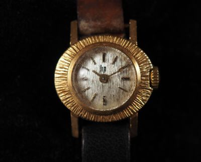 an image of a gold watch on a black background