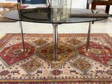 une table en verre avec un plateau en verre posée sur un tapis