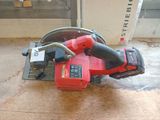 a red corded driller sitting on the floor next to a bucket