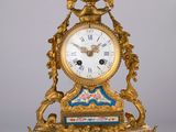 une horloge dorée ornée d'un motif bleu et blanc