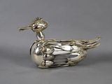 an antique silver duck shaped box with a bird on it ' s head