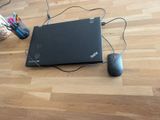 a laptop and a mouse on the floor next to each other