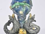 a blue vase with a dragon and a ball on it