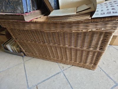 a wicker basket with books stacked on top of it