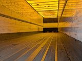a yellow light shining on a wooden floor in a tunnel