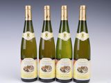 four bottles of wine are lined up on a white surface