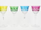 four different colored wine glasses are lined up in a row
