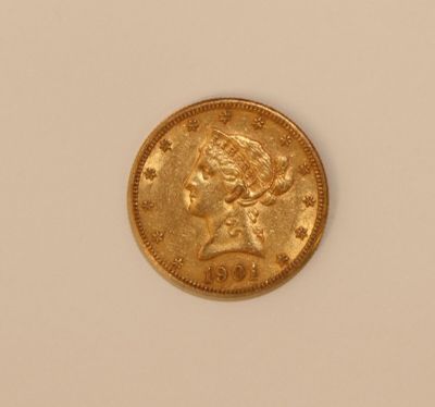 a close up of a gold coin on a white surface