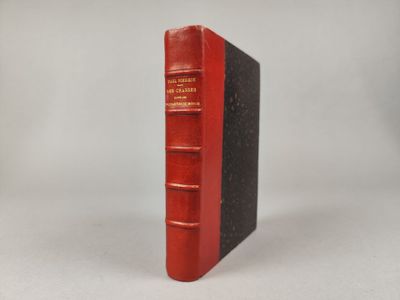 un livre rouge posé sur une table à côté d'un mur blanc
