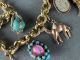 a gold bracelet with charms on it on a table