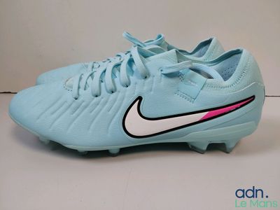 un gros plan sur une paire de chaussures de foot bleues posées sur une surface blanche