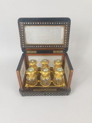 une petite boîte en bois contenant quatre bouteilles