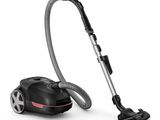 un aspirateur noir et argent muni d'un tuyau, sur fond blanc