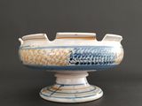 a white and blue bowl on a table with a black background