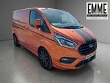 La camionnette orange est garée dans un garage et porte une bande noire.