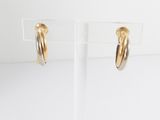 a pair of gold hoop earrings on a clear stand