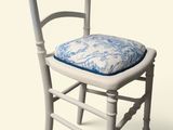 une chaise blanche sur laquelle est posé un coussin bleu