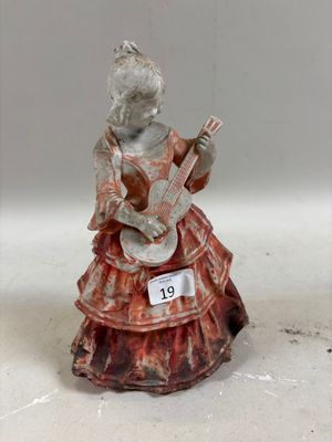 une figurine représentant une femme jouant de la guitare