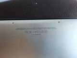 the back of a laptop with a small battery on top of it