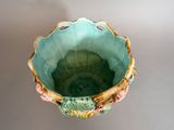 a green bowl with flowers on it on a table