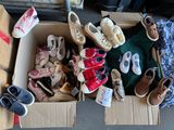 many pairs of shoes in a cardboard box on the floor