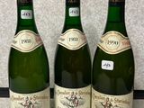 trois bouteilles de vin sont alignées sur un plan de travail