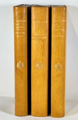 trois livres en bois empilés les uns sur les autres sur une surface blanche
