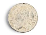 an old silver coin on a white surface with a white background