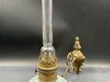 an old fashioned lamp with a glass shade on top of it