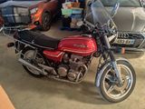 a red motorcycle parked in a garage next to other cars