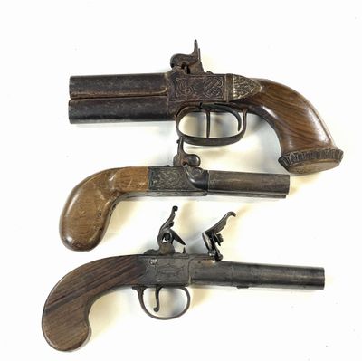 trois vieilles armes à feu sont exposées sur un fond blanc