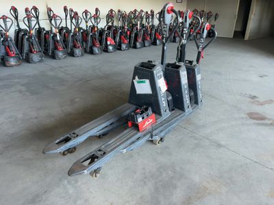 de nombreux types de chariots élévateurs alignés dans un garage