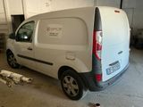 a white van parked in a garage with a dog laying on the floor