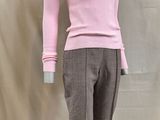 une photo d'un mannequin portant un pull rose et un pantalon marron