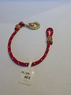 un bracelet en cordon rouge muni d'un fermoir doré