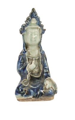 une petite statue représentant un Bouddha assis sur une surface blanche