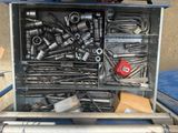 a metal tool box filled with various tools on a table