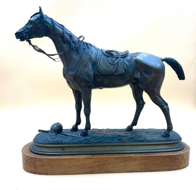 a statue of a horse and a ball on a wooden base