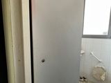 a refrigerator that is in the corner of a bathroom